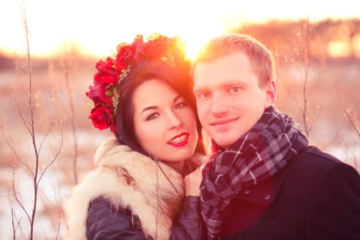 Cheerfull young lovers are smiling and hugging in sunlight