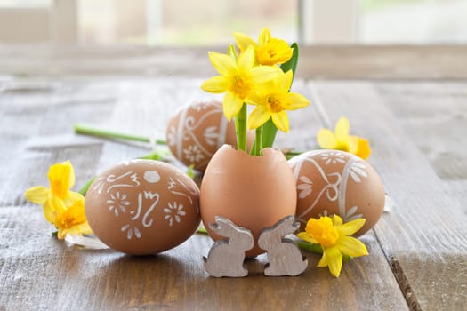 Fresh daffodils in eggshell and painted Easter eggs