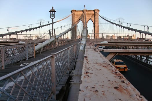 Rusty structure detail of brooklyn bridge  with pedestrian walk and road for cars, New York