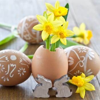 Fresh daffodils in eggshell and painted Easter eggs