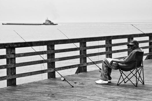 NEW YORK - JUNE 27: Fisherman on a windy day over pier, Coney Island in Brooklyn on June 27, 2008 New York City