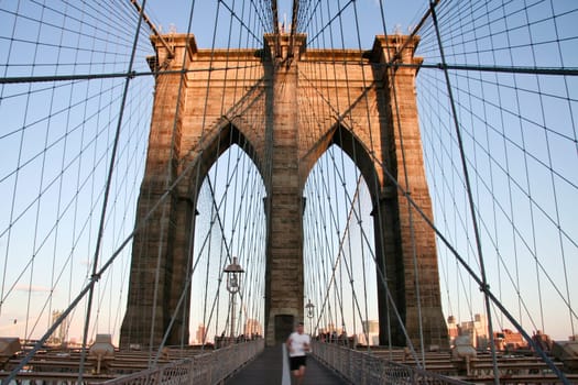 Motion shot of an unrecognizable runner at The Brooklyn Bridge, New York