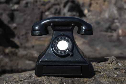 International Communications Vintage Telephone Toy on the Volcanic Rocks