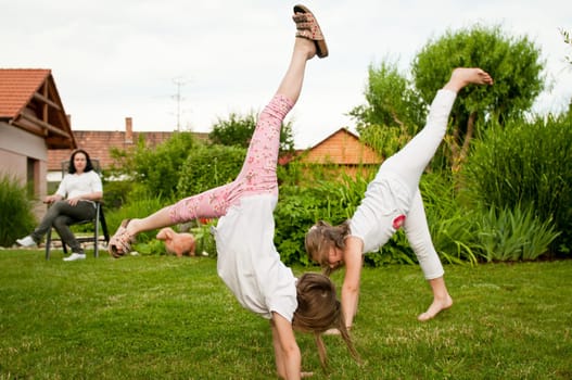 Children doing cartwheels in backyard