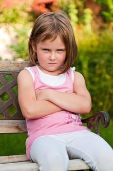 Outdoors portrait of small cute girl with offended look