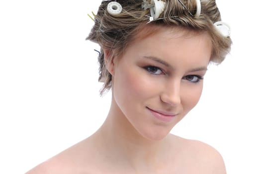 Young beautiful woman with hair rollers in curls isolated on white