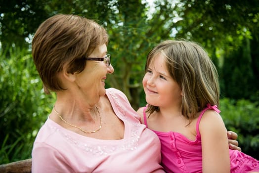 Portrait of grandchild with grandmother - outdoor in backyard