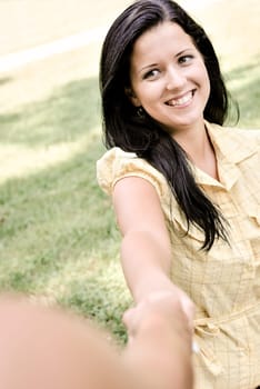 Young smiling woman stretching her hand and receiveing help