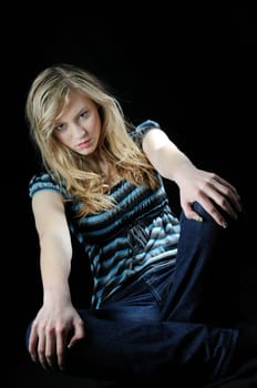 Young beautiful blond depressed woman (teenager)isolated on black background