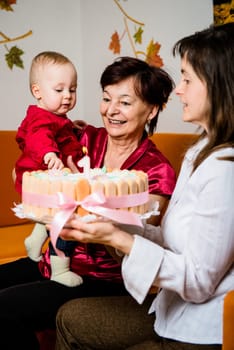 Mother and grandmother with small baby celebrating first birthday