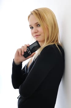 Blond thoughtful young woman holding mobile phone on white background
