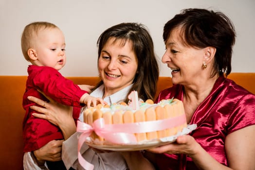 Mother and grandmother with small baby celebrating first birthday