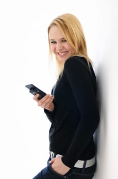 Blond smiling teenage girl holding mobile phone on white background