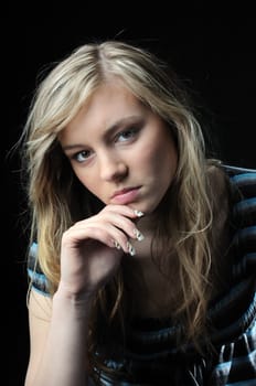 Young sad and thoughtful woman (teenager) isolated on black background