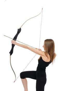 Woman on knee aiming with bow - studio shot