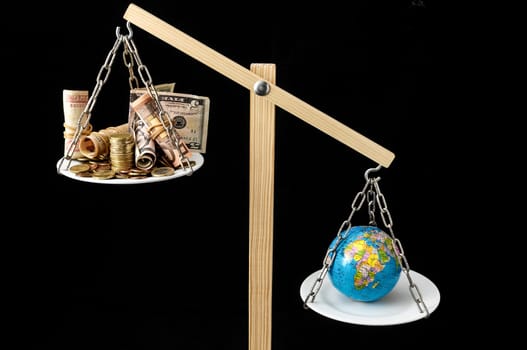 Globe Planet Earth and Money on a Two Pan Balance