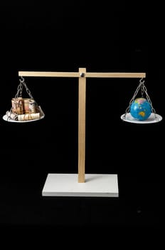Globe Planet Earth and Money on a Two Pan Balance