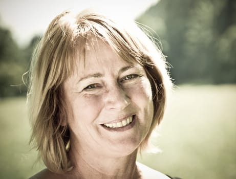 Portrait of happy smiling senior woman - outside on sunny day