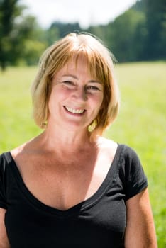 Portrait of happy smiling senior woman - outside on sunny day