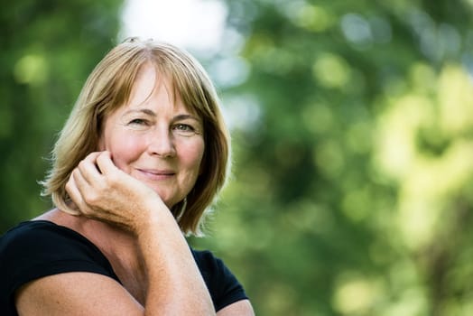 Portrait of happy smiling senior woman - outside on sunny day