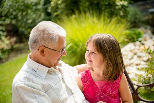 Portrait of grandchild with grandfather - outdoor in backyard
