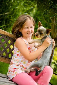 Happy smiling child playing with their pet - outdoor in backyard