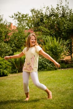 Active childhood - happy child dancing outdoor in backyard