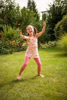Active childhood - happy child dancing outdoor in backyard