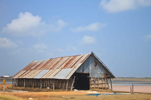 salt in the bamboo basket on the ground near salt pan, Thailand