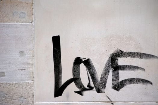 Die Fotografie des Wortes Liebe, welches mit einem Pinsel an die Hauswand gemalt wurde.