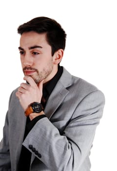 A handsome businessman standing for white background in a light gray .suit with his hand on his chin..