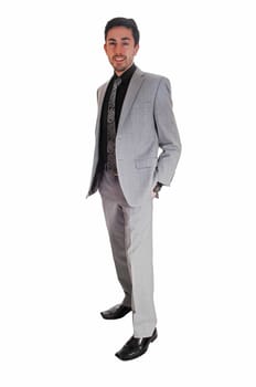 A tall handsome businessman standing for white background in a gray .suit with his hands in his pocket..