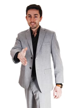 A handsome businessman standing for white background in a gray .suit giving a handshake..