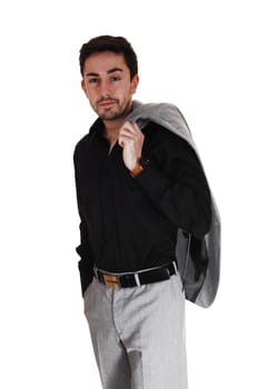 A tall handsome businessman standing for white background in a gray .suit and black shirt with his jacket over his shoulder..