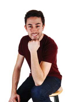 A young man sitting for white background very relaxed .in a portrait picture..