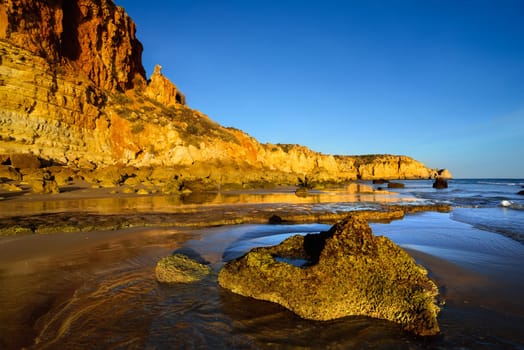 Rocky coast on the Atlantic Ocean in the golden sunlight of the low sun