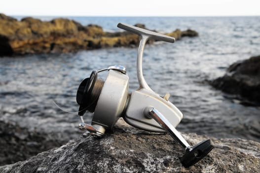 Gray Vintage Old Fishing Reel near the Sea