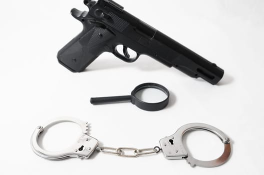 Weapon Crime Concept Gun and Handcuffs on a White Background