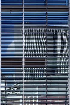 The abstract photograph of high-rise reflections in a façade with blinds
