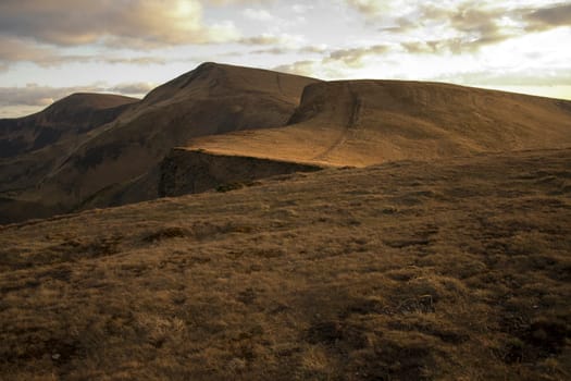 Mountain peaks in the autumn evening sky with clouds