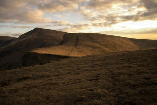 Mountain peaks in the autumn evening sky with clouds