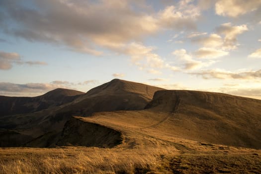 Mountain peaks in the autumn evening sky with clouds