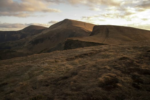 Mountain peaks in the autumn evening sky with clouds