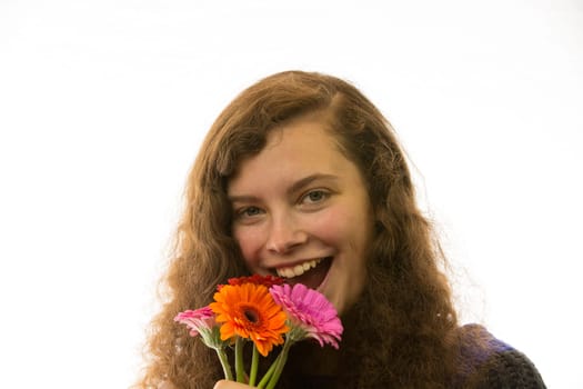 A young pretty woman holds a bouquet of flowers in her hand