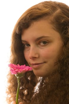 Eine junge hübsche Frau hält eine Blume in der Hand und riecht daran