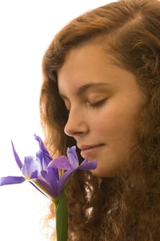 A young pretty woman holds a flower in her hand and smells it