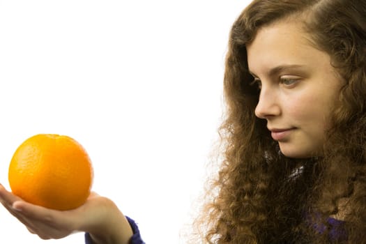 Eine junge hübsche Frau hält eine Orange in der Hand