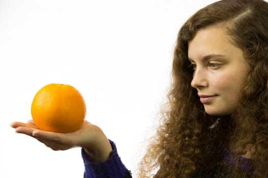 Eine junge hübsche Frau hält eine Orange in der Hand