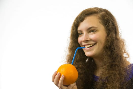 Eine junge hübsche Frau hält eine Orange mit Strohhalm in der Hand