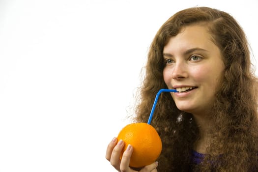 Eine junge hübsche Frau hält eine Orange mit Strohhalm in der Hand